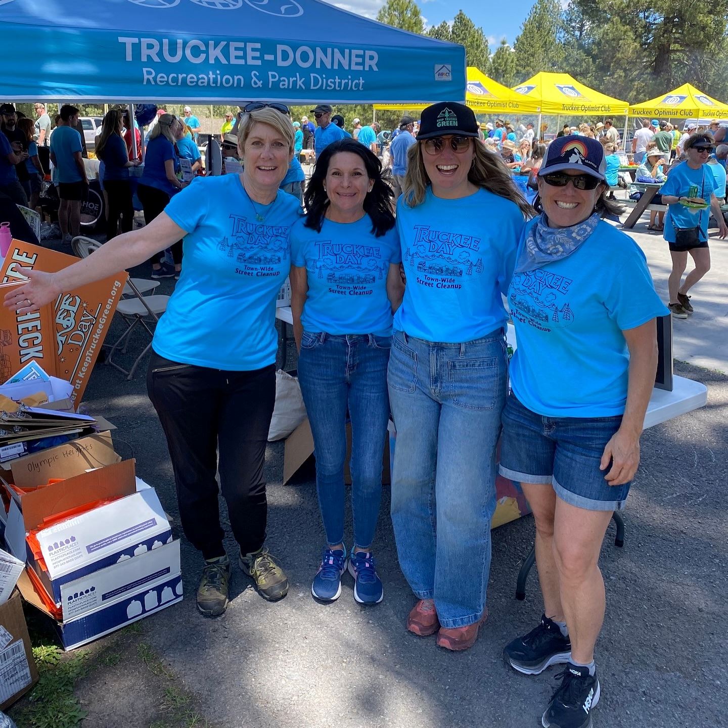Four women smiling at the camera at the Truckee Day block part event in matching blue shirts. 